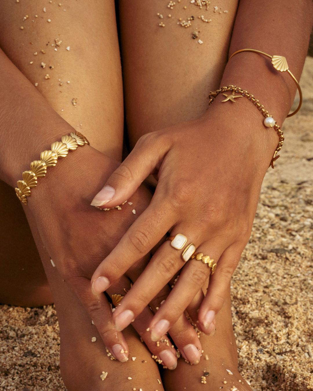 beeachy gold jewelry stack with chunky and dainty Shell Bracelet Cuffs, a charm bracelet and mathcing rings - Haylo & Co.