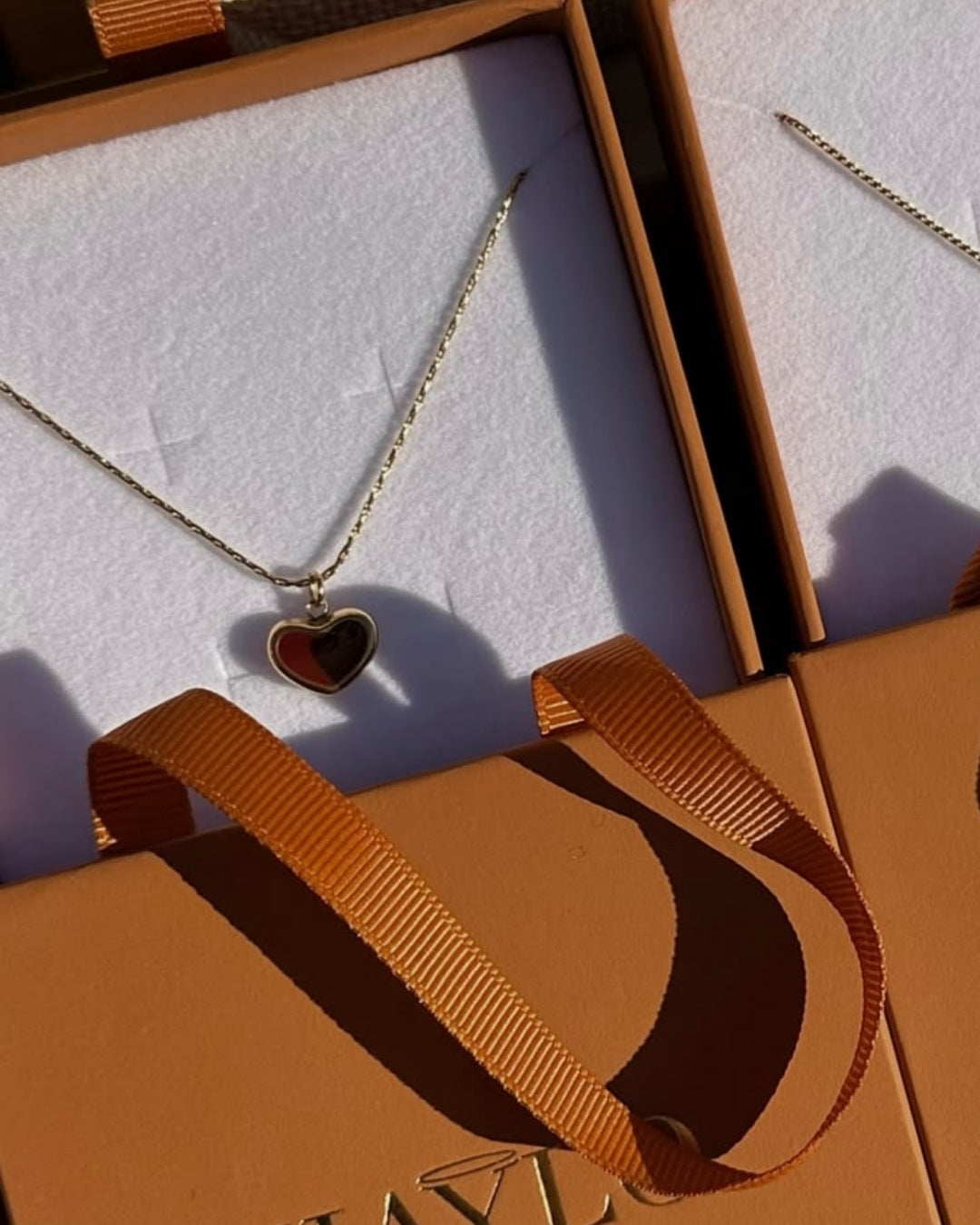 gold heart necklace with a cherry red heart