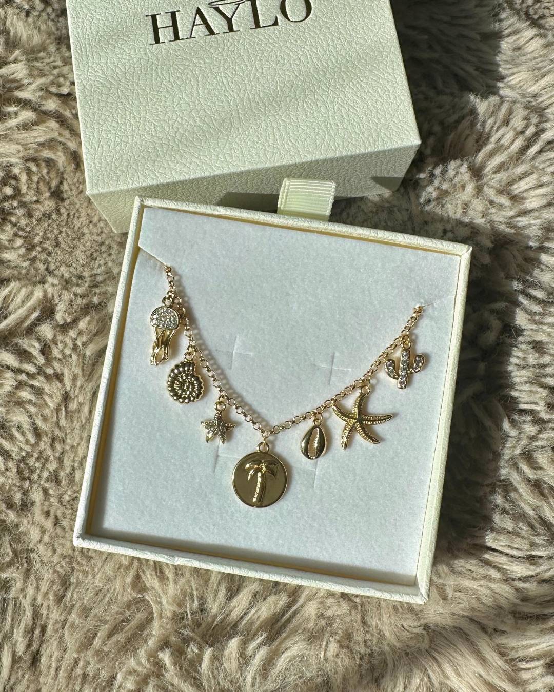 gold coastal charm necklace with ocean charms