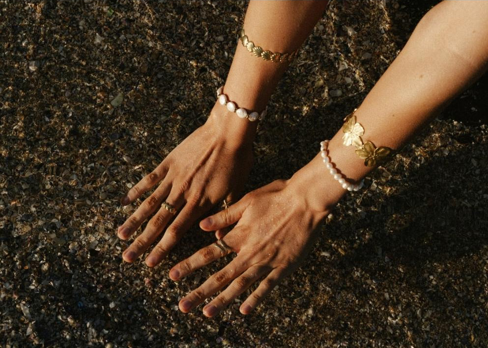 hands in the ocean with jewlery on