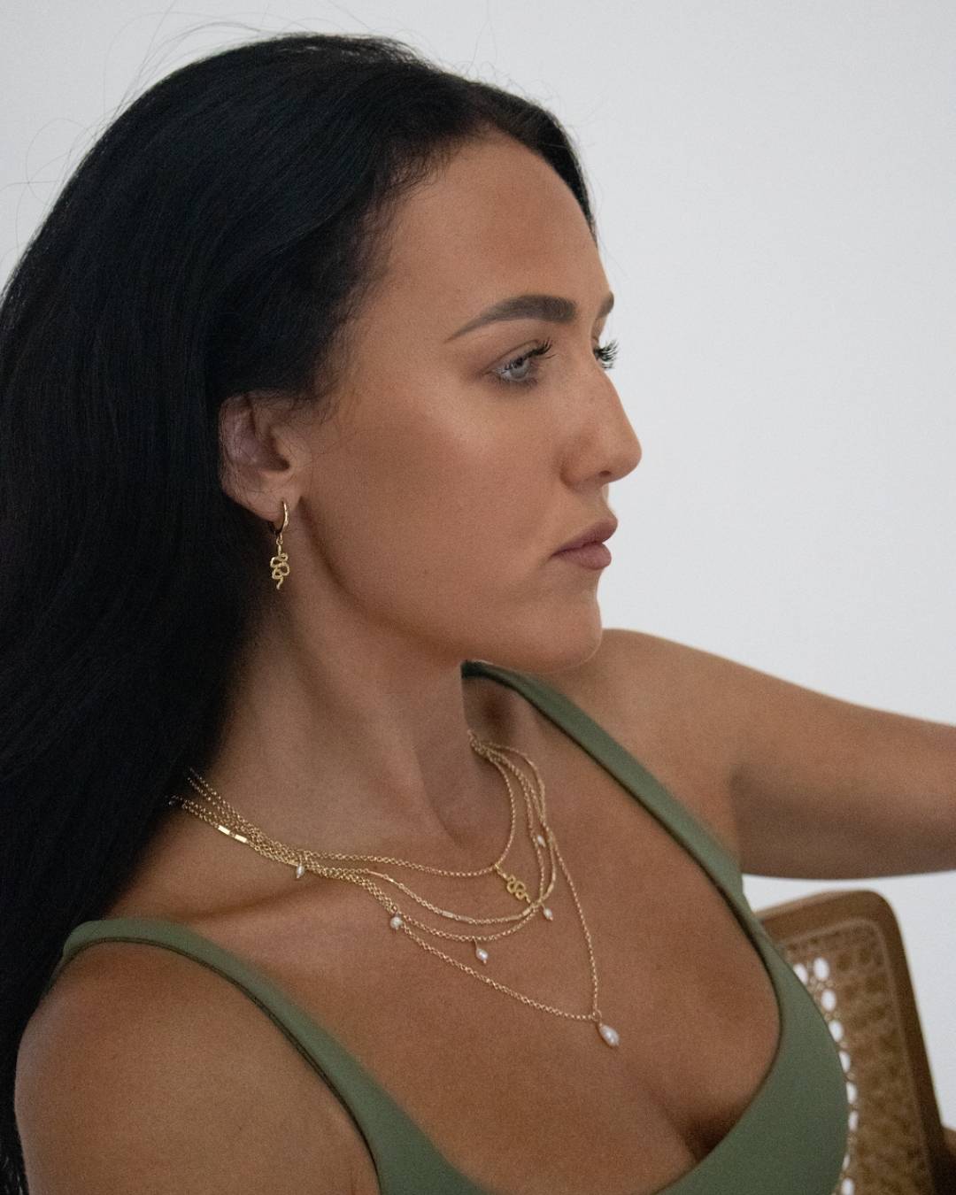 Woman wearing gold snake necklaces and earrings